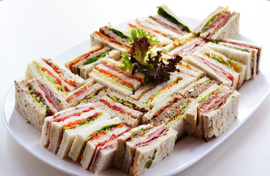 Assorted sandwiches on a white platter.